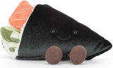 A plush Amuseables Comeroi Temaki toy pillow shaped like a piece of nigiri sushi, featuring a black body, brown feet, a smiling face, and colorful accents of orange, green, and white representing salmon, avocado, and rice.