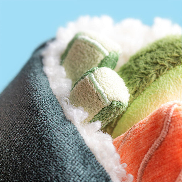 Close-up of a Amuseables Comeroi Temaki with green, orange, and white patterns against a blue background