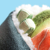 Close-up of a Amuseables Comeroi Temaki with green, orange, and white patterns against a blue background