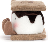 A plush toy designed like a s'mores sandwich, featuring a white body, dark brown faux-chocolate drizzle, and tan corduroy-style cracker layers with a small pink blush on the side.