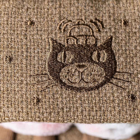 Embroidered cat design on a textured fabric surface
