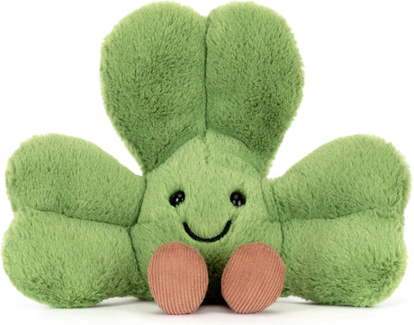 Amuseables Siofra Shamrock plush toy with a friendly smile, soft green fabric shaped like a shamrock, and small brown feet, perfect for kids and as a cheerful gift.