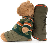 A plush Bartholomew Bear Hiking Outfit wearing a green, orange, and white patterned sweater and olive green pants, sitting next to a matching olive green backpack with orange piping on a white background.