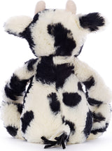 Soft plush toy with black and white spots resembling a cow, featuring small ears and a tufted tail, named Bashful Calf.