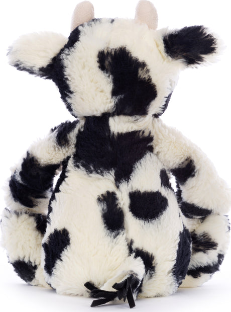 Soft plush toy with black and white spots resembling a cow, featuring small ears and a tufted tail, named Bashful Calf.