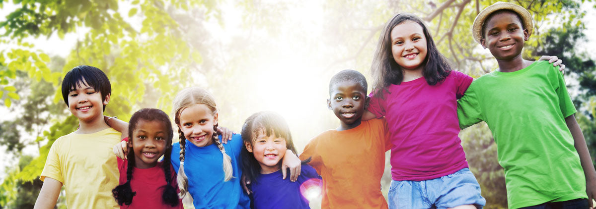 Smiling Children in a row with tree branches and sun in background  - Join us as we partner with our library in promoting reading for children of all ages!!r