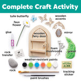 Collection of items for a complete craft activity including a wooden fairy door, paintbrushes, and various decorative elements.