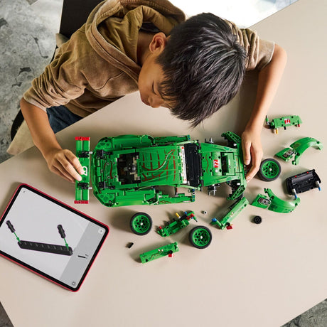 Child building a LEGO Technic: Porsche 911 GT3 R REXY AO Racing Car