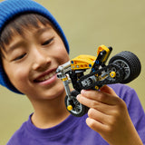 Child holding a LEGO Technic: Yellow Motorcycle toy motorcycle with a blurred background