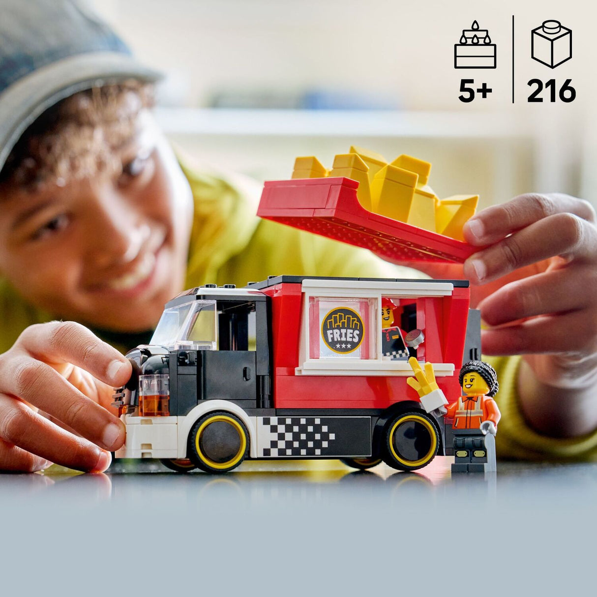 Child playing with a toy LEGO City Great Vehicles: Fries Food Truck and character, with a focus on the product and age recommendation.