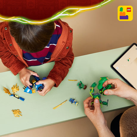 Two people playing with LEGO LEGO Ninjago: Jay's Dragon Mech Fight set at a table, with a tablet displaying a LEGO app in the background.