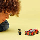 Child playing with a LEGO Super Heroes Marvel: Spider-Man Car vs. Venomized Wolverine kit and figure on a yellow background