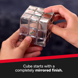 The Official Rubik's Pulse , Person holding a mirrored Rubik's Cube with a dark background