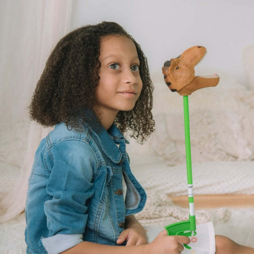 Child holding a Brown T-Rex Snapper Toy against a neutral background