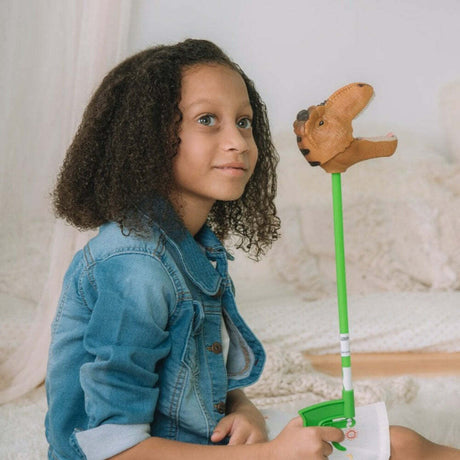 Child holding a Brown T-Rex Snapper Toy against a neutral background