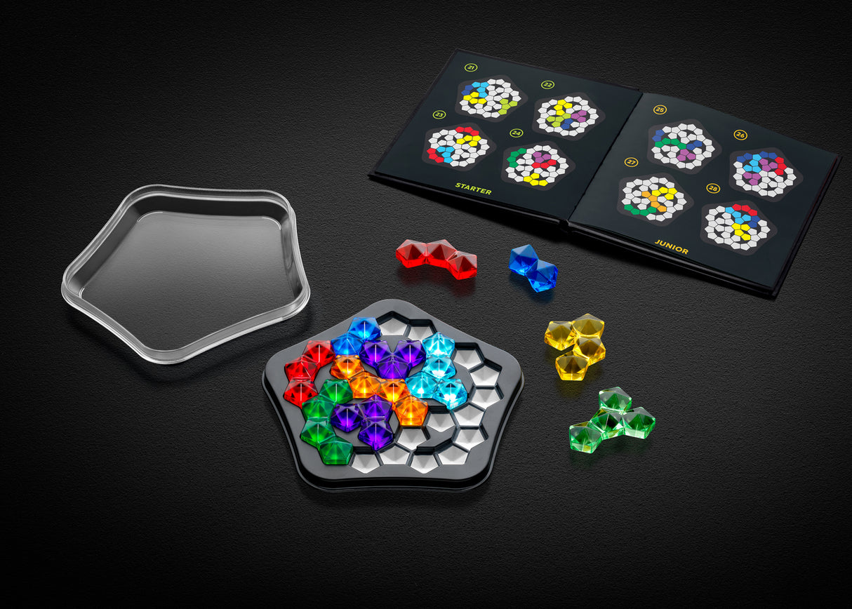 Colorful IQ Deluxe - Pentagon pieces on a black surface with puzzle board and trays.