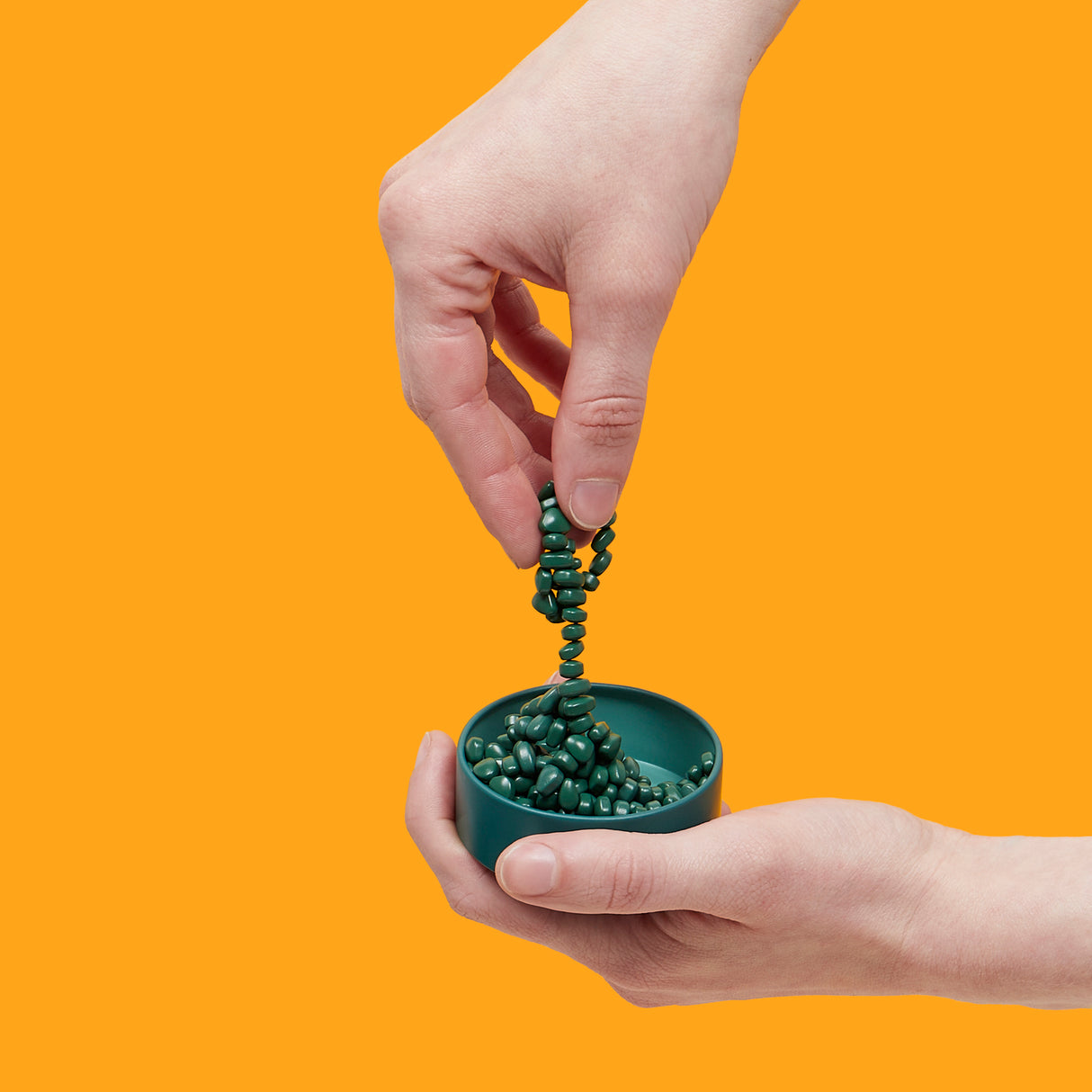 Person holding Mini Matte Crags Jade against an orange background