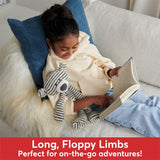Person sitting on a couch with a book and plush Stripe Toothpick Bear - 15 In toy, surrounded by pillows.