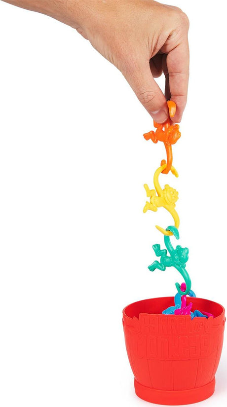 Colorful Barrel of Monkeys game pieces with a hand pulling on one of its parts, set against a white background.