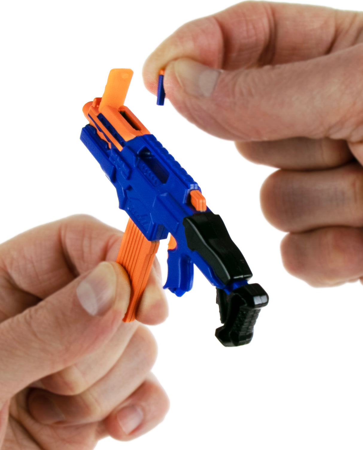 Close-up of a person assembling a blue and orange World's Smallest Nerf Blasters.