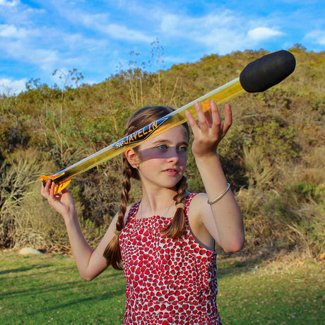 Girl holding a Bad Rap Javelin outdoors with greenery in the background