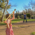 Girl in a red dress holding a Bad Rap Javelin in a park with a boy in the background