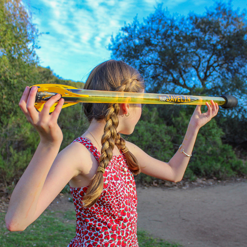 Person holding a Bad Rap Javelin above their head with trees and blue sky in the background