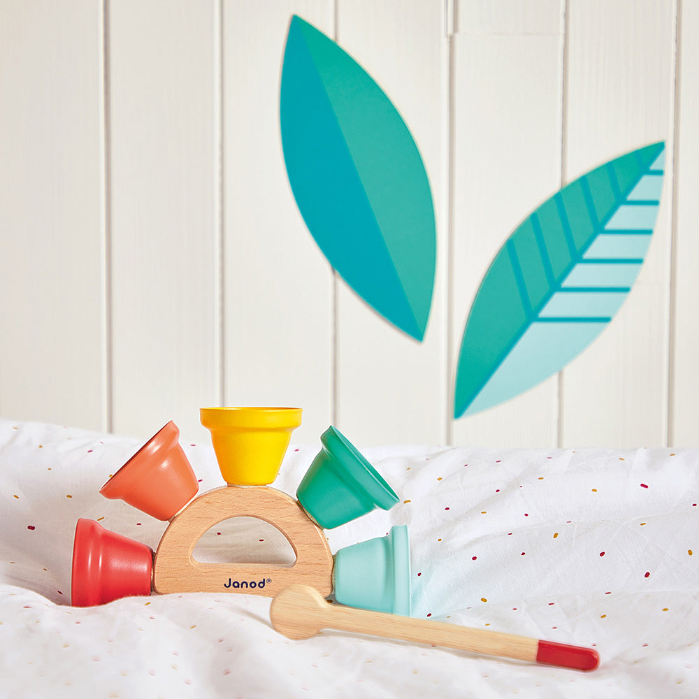 Colorful Musical Handbell on a white surface with leaf decorations.