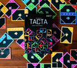 Board game box for 'TACTA' surrounded by colorful game cards on a wooden surface