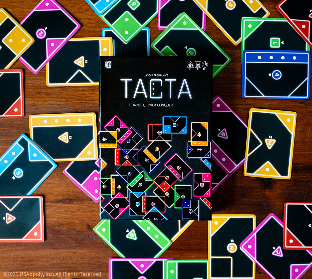 Board game box for 'TACTA' surrounded by colorful game cards on a wooden surface