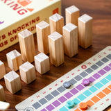 Cats Knocking Things Off Ledges Balance Game with wooden blocks and colorful game board on a wooden surface