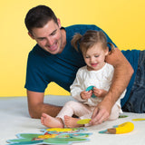 Man and young girl playing Monkey Around Game on a yellow background