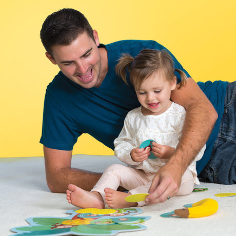 Man and young girl playing Monkey Around Game on a yellow background