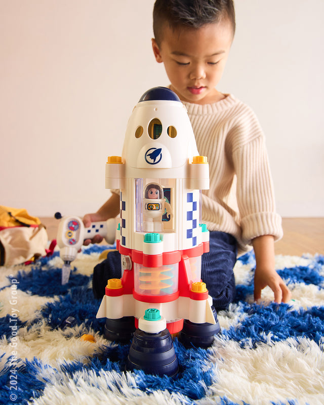 Child playing with a Space Adventure Take Apart Rocket Ship on a blue and white rug