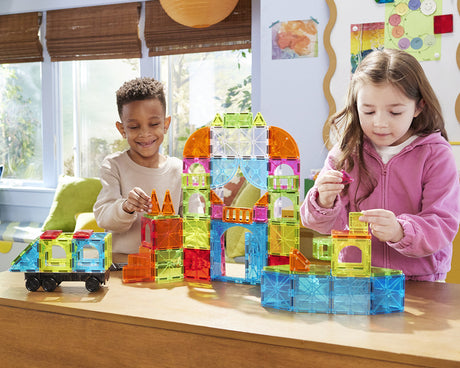 Two children playing with colorful Magna-Tiles City Center 110 Piece Set on a table.