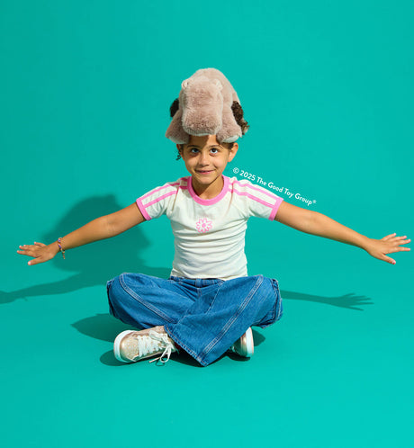 Child with a Pygmy Hippo Super Soft  sitting on a teal background