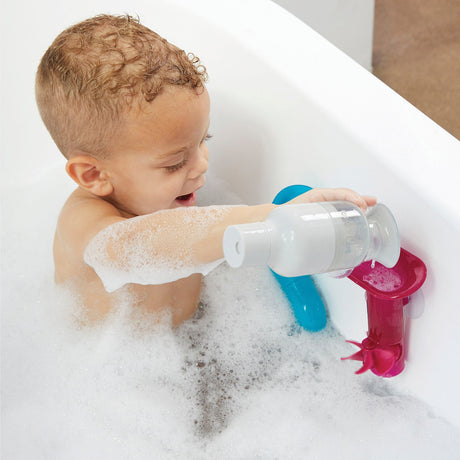 Child playing with a colorful bath toy in a bathtub filled with bubbles