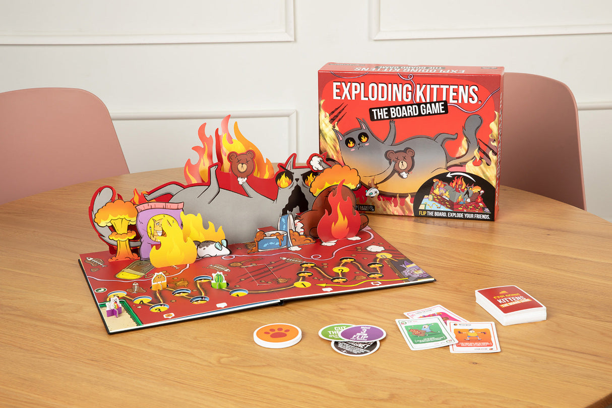 Exploding Kittens board game set up on a table with game pieces and box.