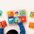 Child playing with a PlayTab - Modular, Sensory, Activity Board on a white surface
