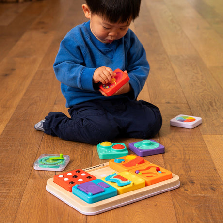 Child playing with a PlayTab - Modular, Sensory, Activity Board on a wooden floor