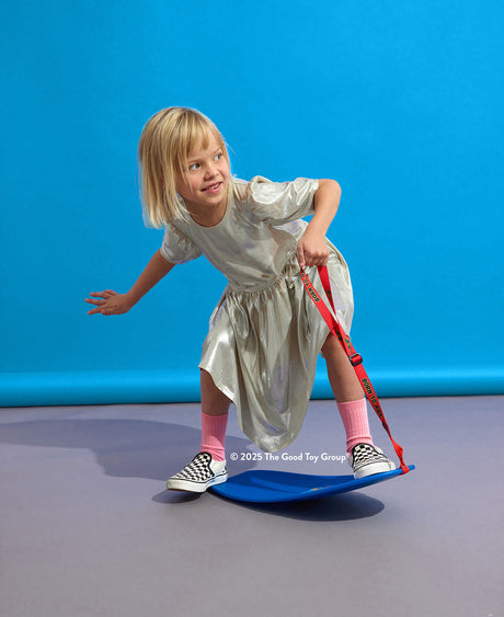 Child playing with a blue The Spooner Mini Pro Born to Ride Training System - 20" against a blue background