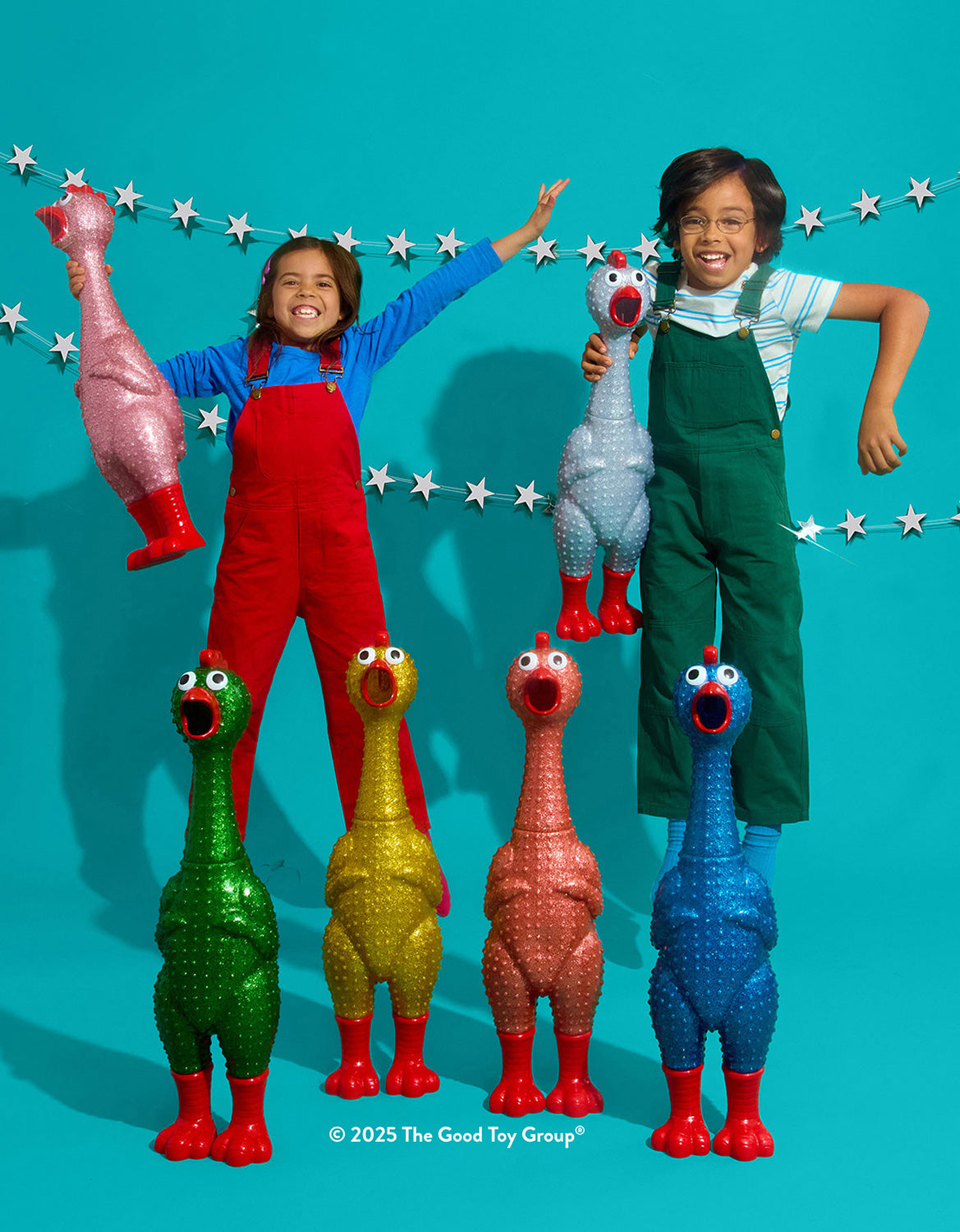 Two children playing with Giant Sparkle Rubber Chicken against a blue background