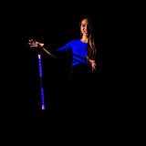 Woman holding a purple Wandini Glow.0 Magic LED Levitation Wand against a black background