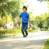 Child jumping rope in a park with trees and flowers in the background