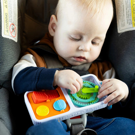 Child playing with a colorfulPlayTab Go in a car seat