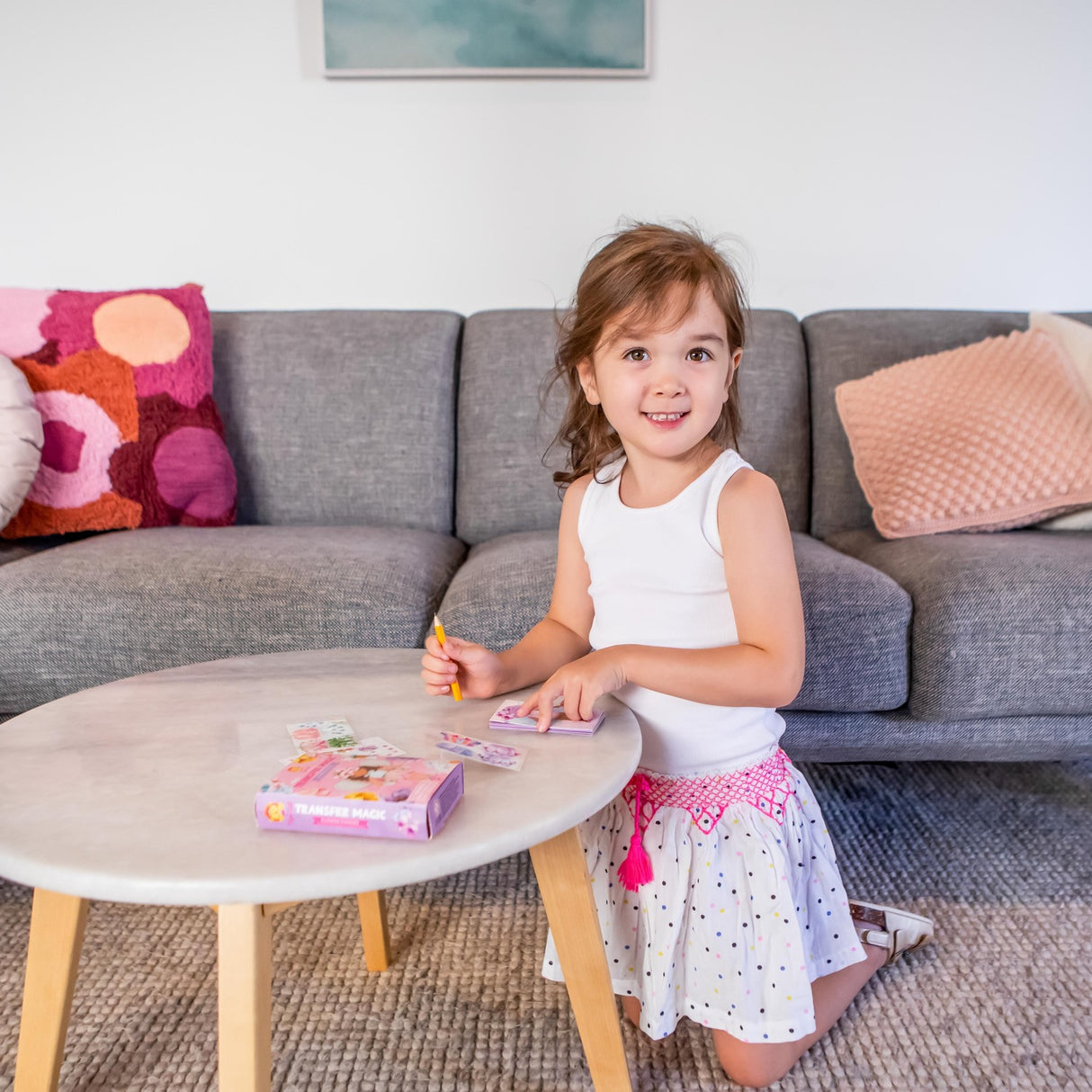 Young girl playing Mini Transfer Magic - Flower Fairies on a small table in a living room.
