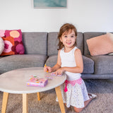 Young girl playing Mini Transfer Magic - Flower Fairies on a small table in a living room.