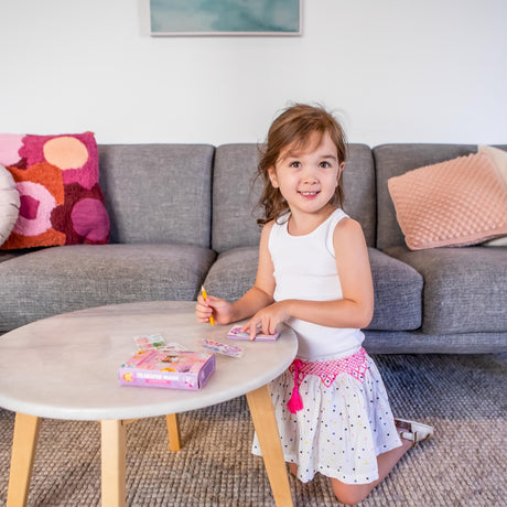 Young girl playing Mini Transfer Magic - Flower Fairies on a small table in a living room.