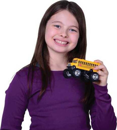 Young girl holding a toy Monster School Bus against a white background