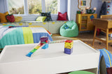 Children's room with a white activity table, Rail Racers - 33 Piece Set , and a bean bag chair.
